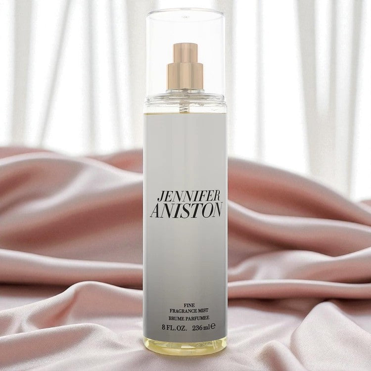 High-quality image of the Jennifer Aniston Fine Fragrance Mist (8 oz / 236 ml) displayed upright on soft pink satin fabric with sheer white curtains in the background. The image evokes a luxurious, feminine, and elegant atmosphere — ideal for promoting premium scent experiences. Perfect for use on Shopify, TikTok Shop, and beauty campaigns.