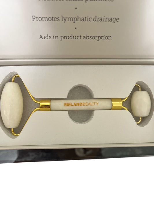 Close-up of white jade facial roller showing natural Xiuyan jade texture