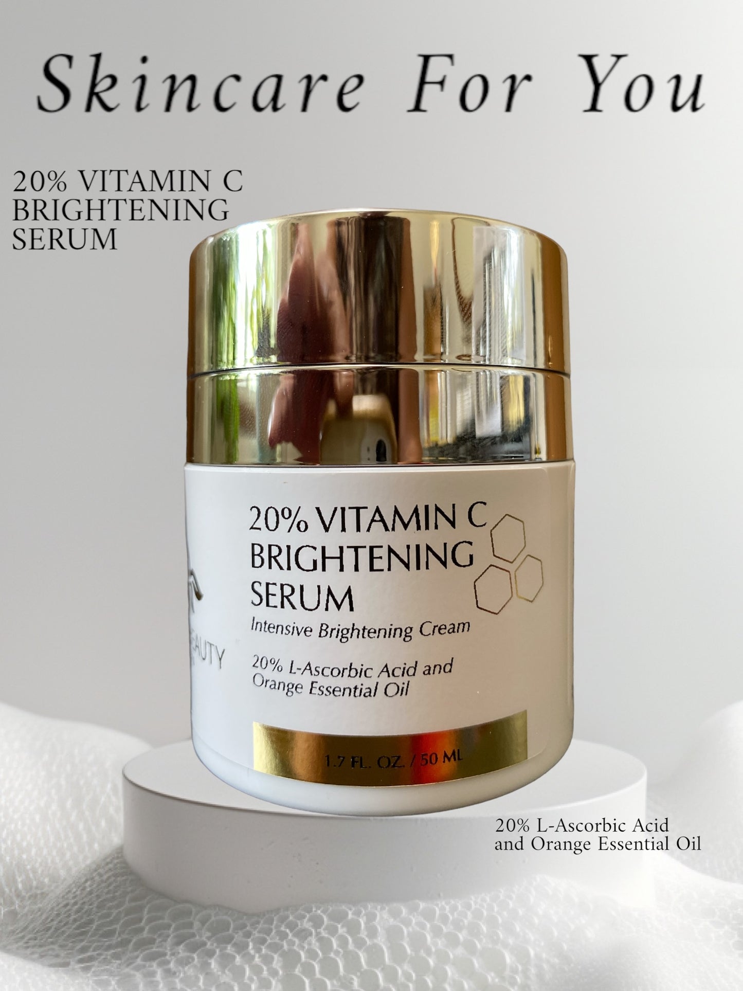 Reiland Beauty Products 20% Vitamin C Brightening Serum displayed on a white pedestal with soft lighting. The luxurious gold-accented jar highlights its powerful formula containing L-Ascorbic Acid and Orange Essential Oil for radiant, even-toned skin.