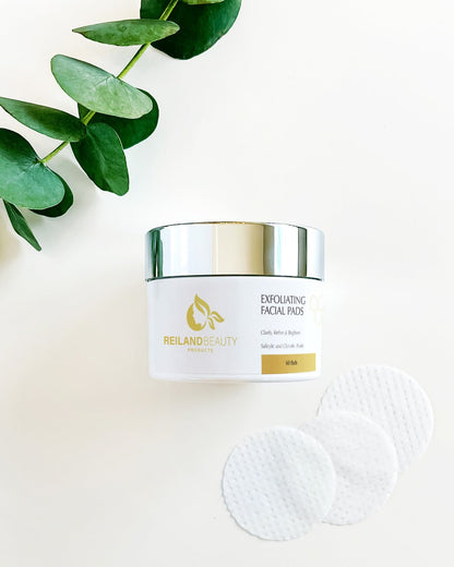 Angled photo of Reiland Exfoliating Facial Pads container highlighting luxury gold logo and clean label design with key benefits for skincare routine.