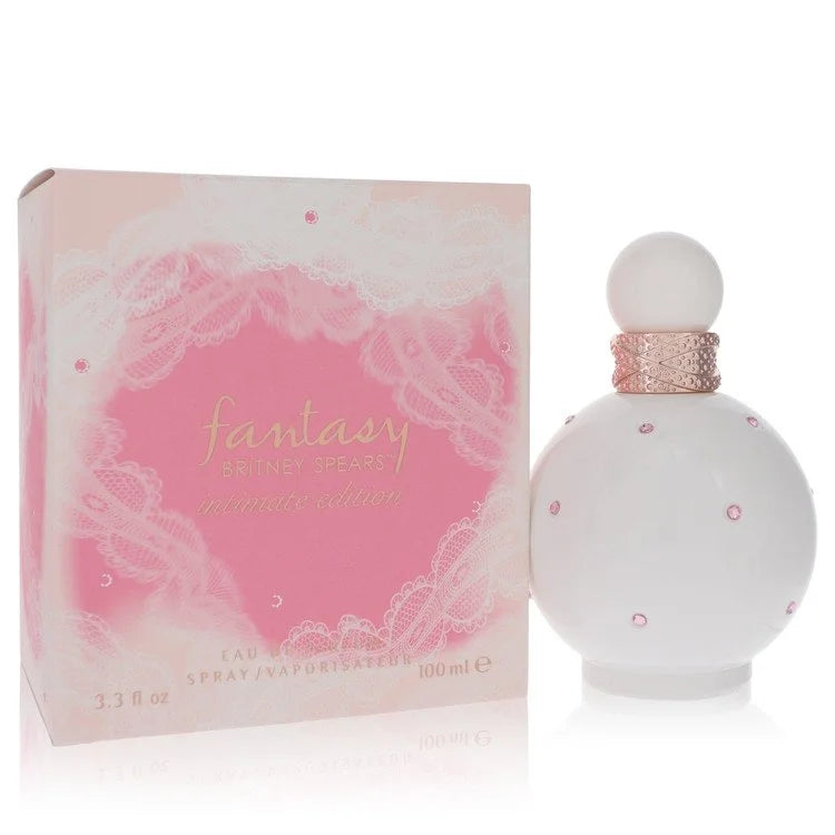 A 3.3 oz white perfume bottle with rose gold accents, displayed beside a soft pink lace-themed box. A delicate, sensual twist on the original Fantasy scent.