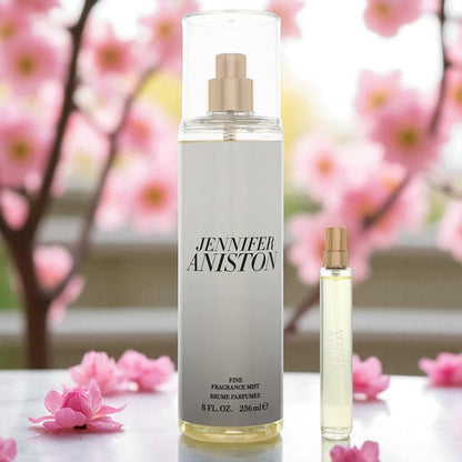 Jennifer Aniston Duo Fragrance Gift Set displayed in a blooming spring setting with soft pink flowers. Features the full-size 8 oz Body Mist and 0.5 oz Mini Perfume Spray, standing side by side on a clean surface. Ideal for showcasing luxury, freshness, and seasonal appeal.