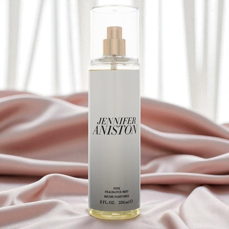 High-quality image of the Jennifer Aniston Fine Fragrance Mist (8 oz / 236 ml) displayed upright on soft pink satin fabric with sheer white curtains in the background. The image evokes a luxurious, feminine, and elegant atmosphere — ideal for promoting premium scent experiences. Perfect for use on Shopify, TikTok Shop, and beauty campaigns.
