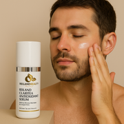 A young man applies Reiland Claritea Antioxidant Serum to his face beside the product bottle, highlighting its calming and clarifying benefits for all skin types.