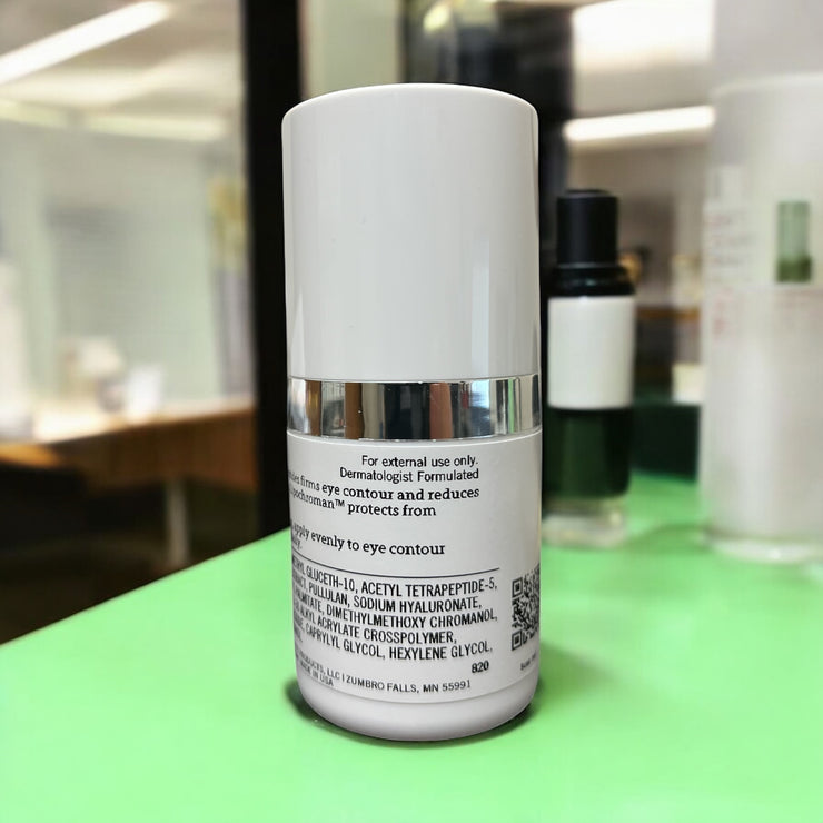 Rear label of Reiland Ultra Benefit Eye Gel in a spa-clinic setting with other skincare bottles in view, conveying a professional skincare environment.