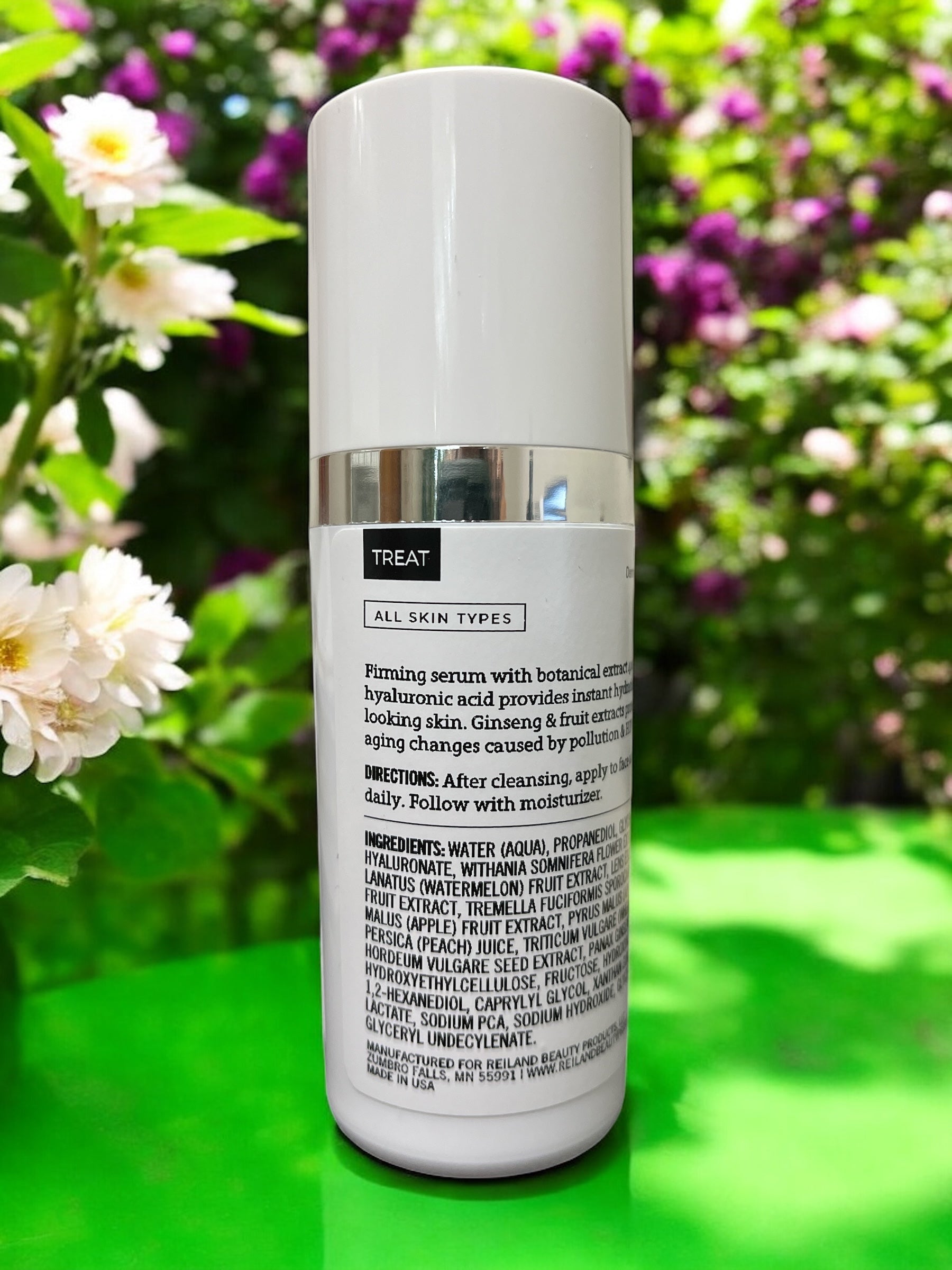 Reiland Hydralift Firming Serum featured in a floral garden setting, highlighting its botanical-based anti-aging skincare formula.