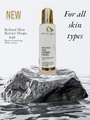 Reiland Skin Barrier Drops displayed on a black volcanic rock with water ripples, highlighting its luxurious, hydrating, and skin-fortifying benefits. This milky serum is enriched with Niacinamide, Ectoin, and Jojoba Milk to restore hydration, balance the microbiome, and strengthen the skin barrier. Ideal for all skin types.