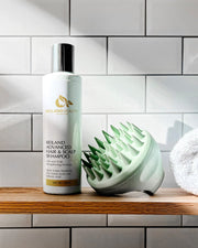 Reiland Advanced Hair & Scalp Strengthening Shampoo with Free Scalp Massager – 6 fl. oz. bottle. Triple Action Postbiotic formula with Oat Amino Acids and Salicylic Acid. Promotes healthy hair growth, clears buildup, and soothes dry scalp.
